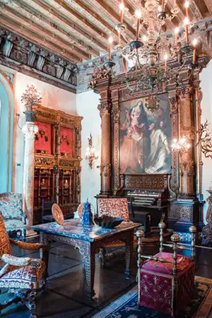 Ornate fine art gallery room with antique furnishings and framed paintings