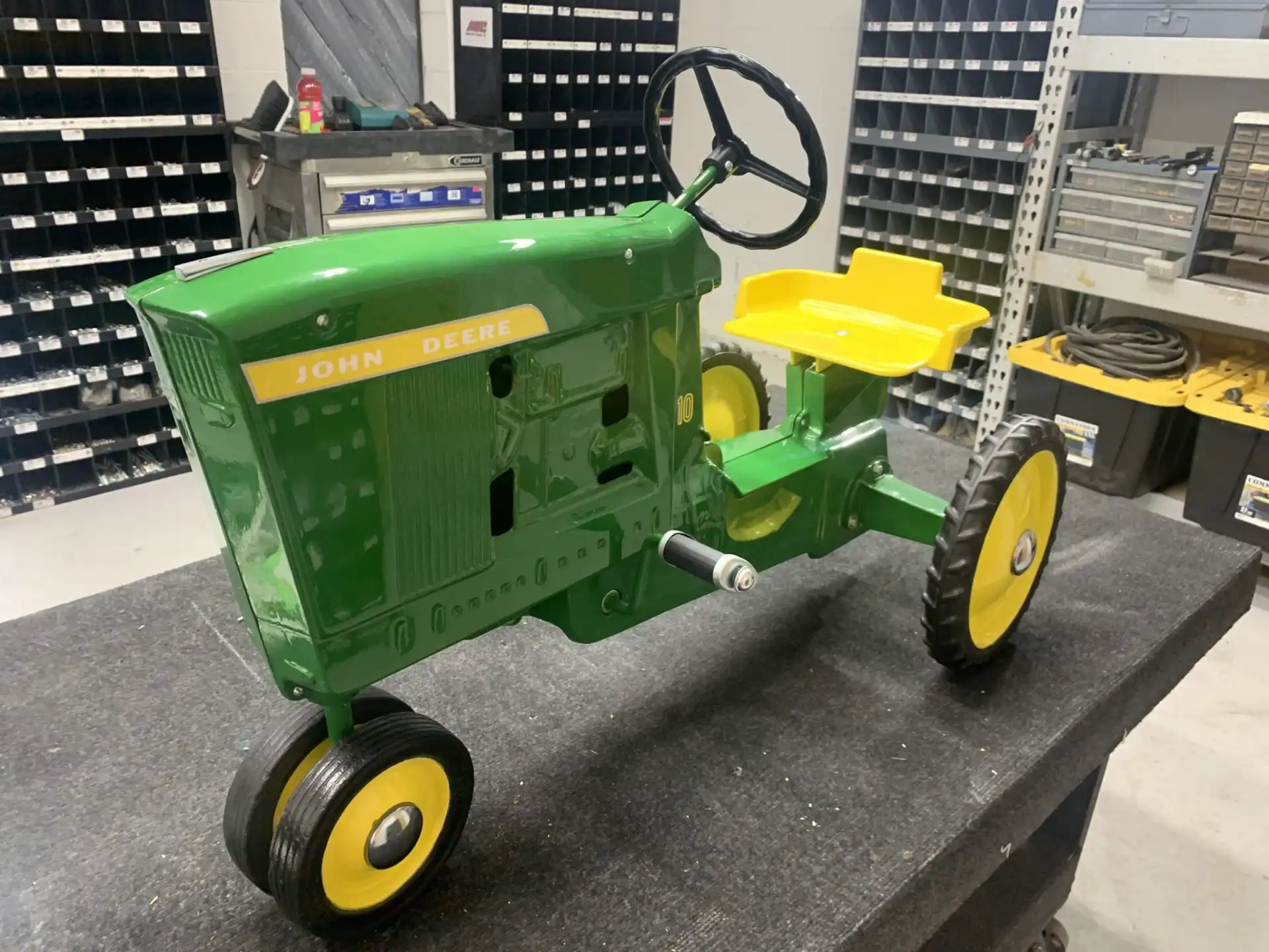 Restored vintage John Deere pedal tractor ready for shipping