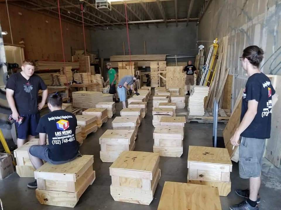 Crew building custom wooden crates in the warehouse
